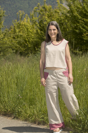 Ensemble avec un débardeur en lin écru et découpes sur les côtés en gaze brodée baie et un pantalon assorti en lin écru et poches et volants baie