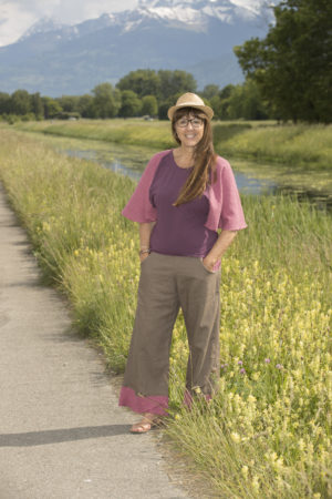 Tenue composée d'un pantalon en lin couleurs olive avec poches et volants à l'ourlet en coton brodé couleur baie et d'un t-shirt manches chauve-souris assorti dans les ton baie et prune