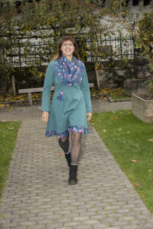 Femme marchant dans une robe menthe en sweat de coton, robe d'hiver, avec un tour de cou assorti au volant de la robe et de son motif de renard