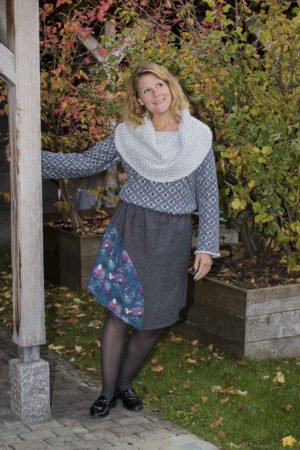 jupe en tweed anthracite chiné en pointe avec une découpe en imprimé avec paysages et animaux hivernaux, portée avec un pull en tricot à col