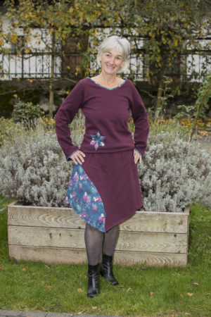 Jupe bordeaux en pointe avec une découpe en imprimé avec paysages et animaux hivernaux, assorti à son pull